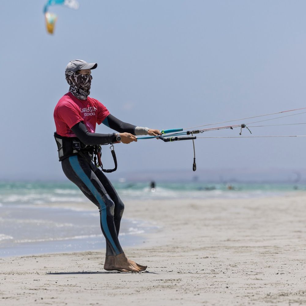 An instructor demonstrating the control bar, lines running out to the kite