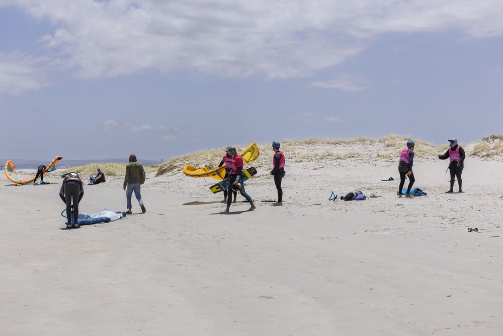 A group setting up kites on the beach on a summer afternoon