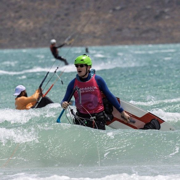 A rider setting up on the board in the water, bar in both hands