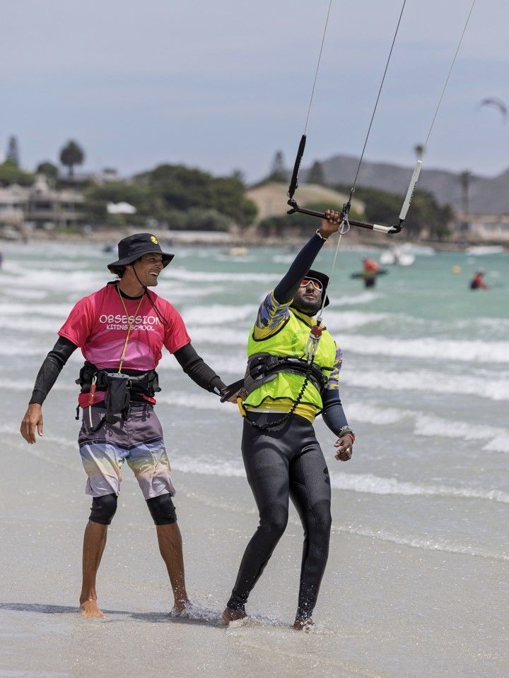 An instructor walking a student out into the water at the start of a lesson