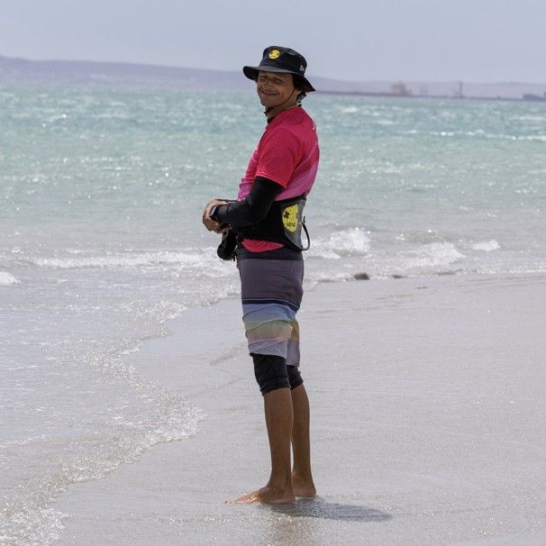 An instructor standing in the shallows watching a student ride