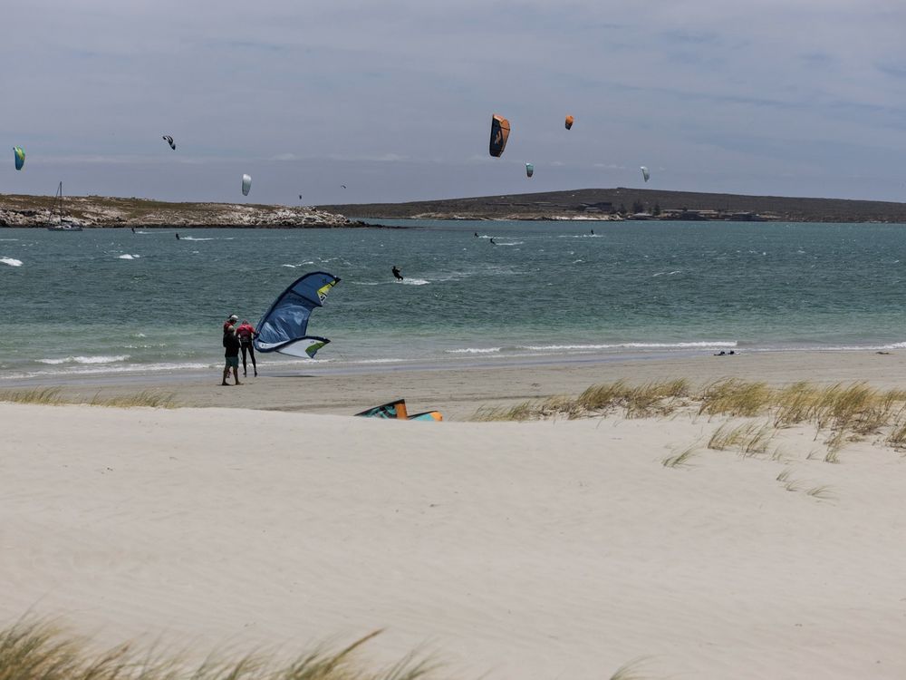 Kites laid out on the sand at Langebaan with the lagoon beyond