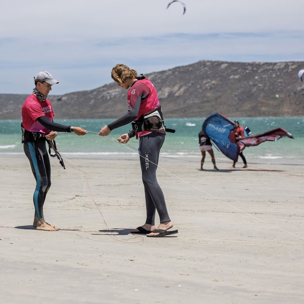 An instructor and student going through the lines on the beach