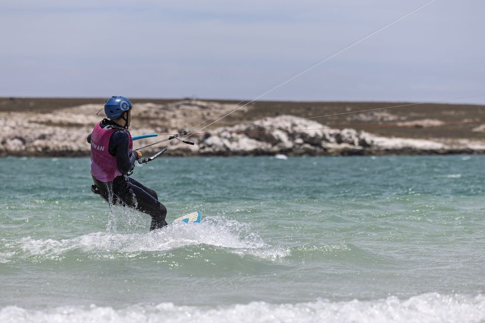A kitesurfer riding across the flat water of the Langebaan lagoon