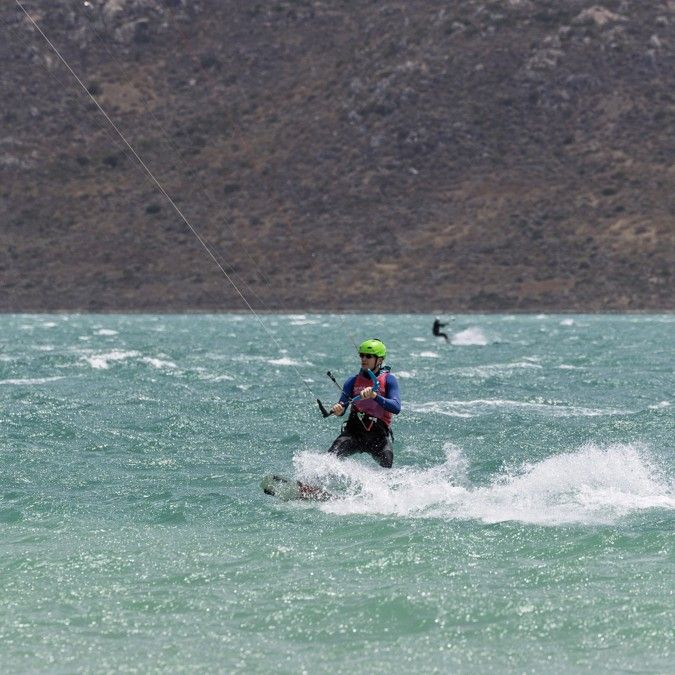 A kitesurfer riding past the beach at Langebaan