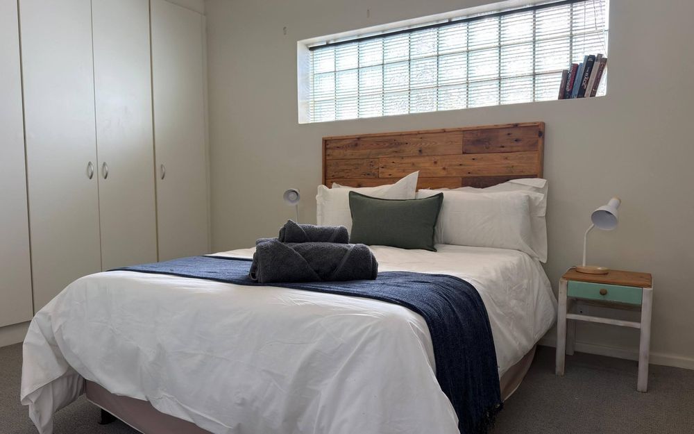 The bedroom at Down Time, with a double bed and fitted cupboards