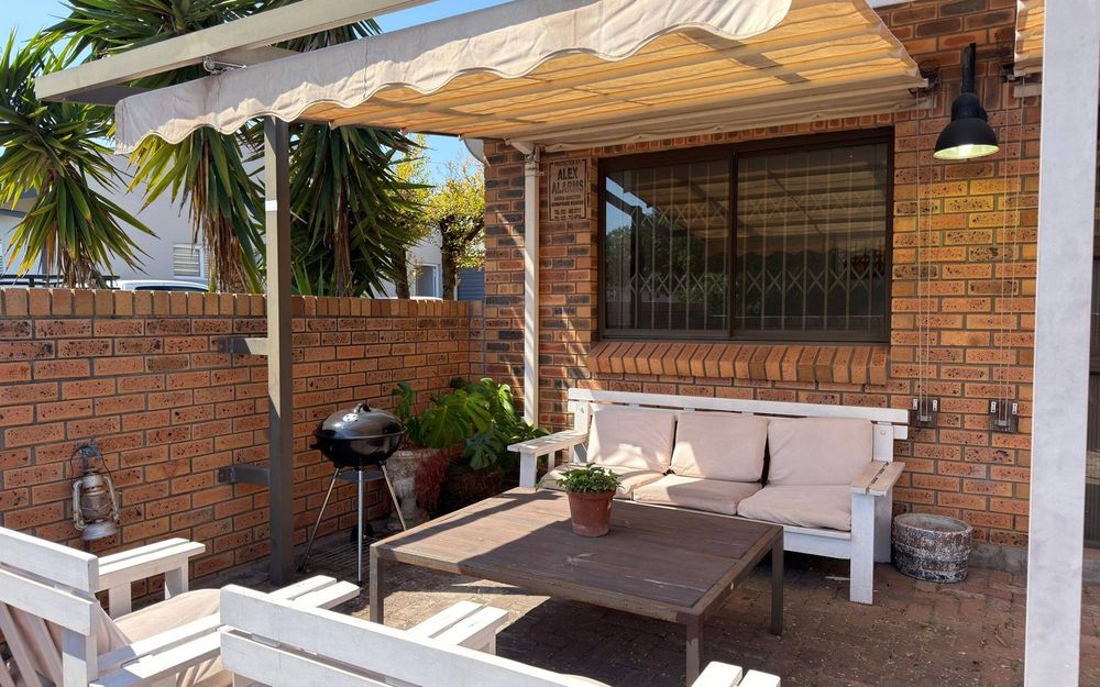 The covered, walled patio at Down Time with a braai and seating