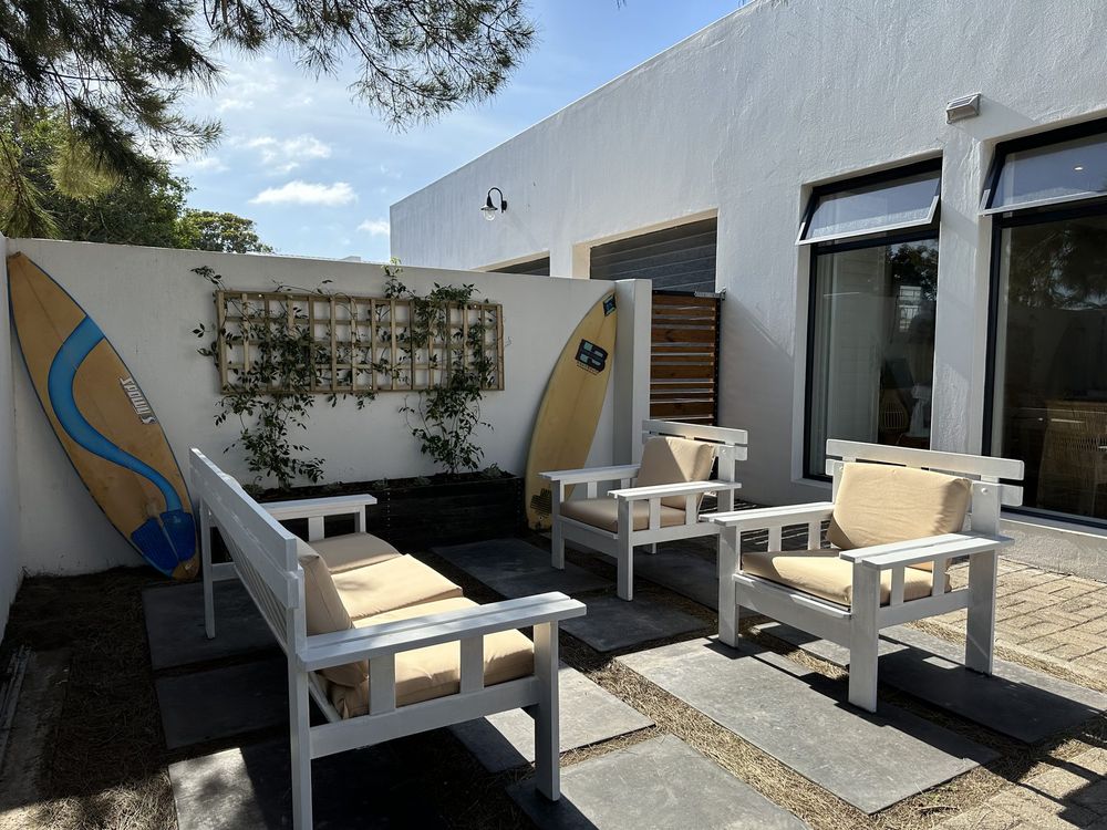 The sheltered patio at Kite Cottage with surfboards against the wall